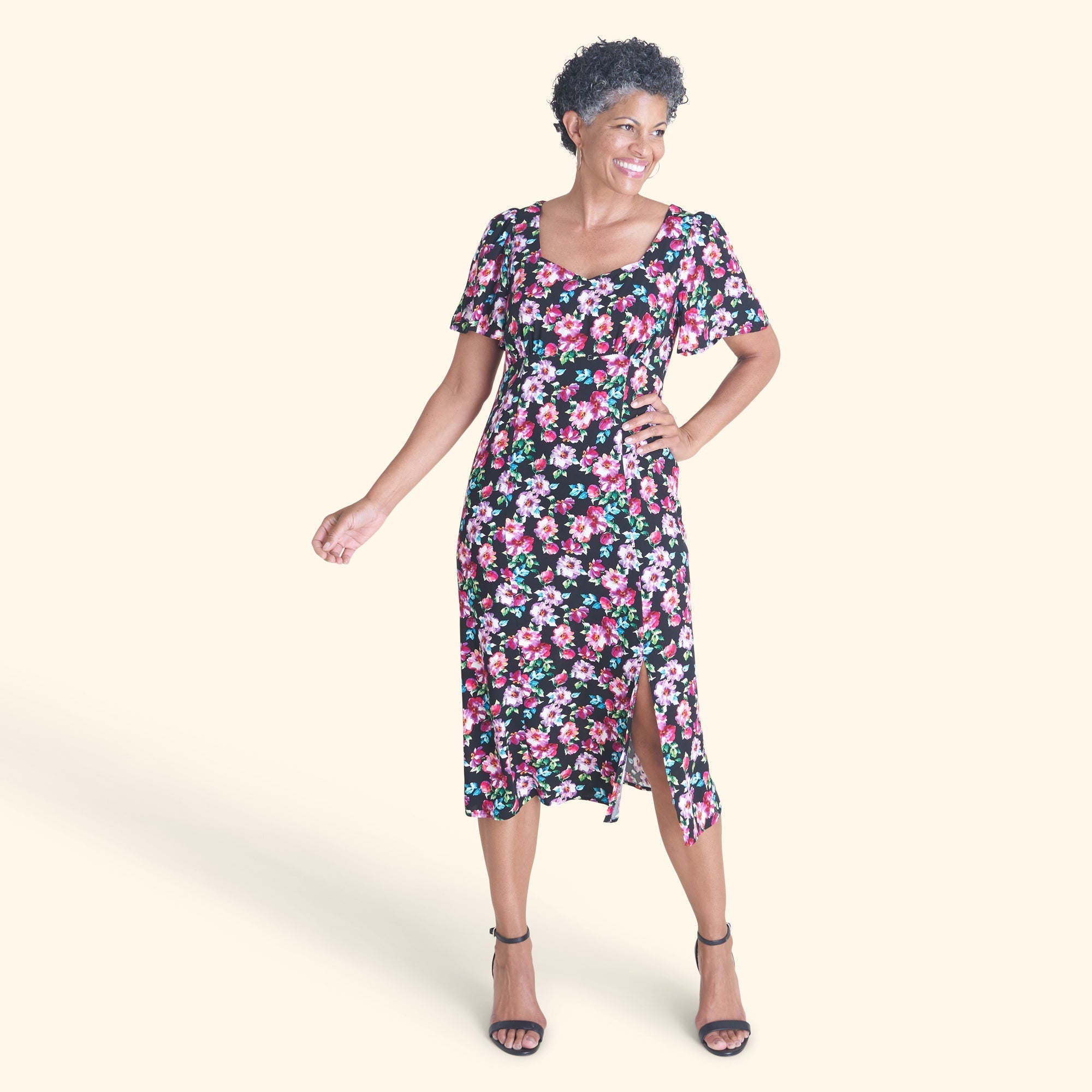Woman posing wearing Black Adrian Floral Midi Dress from Connected Apparel