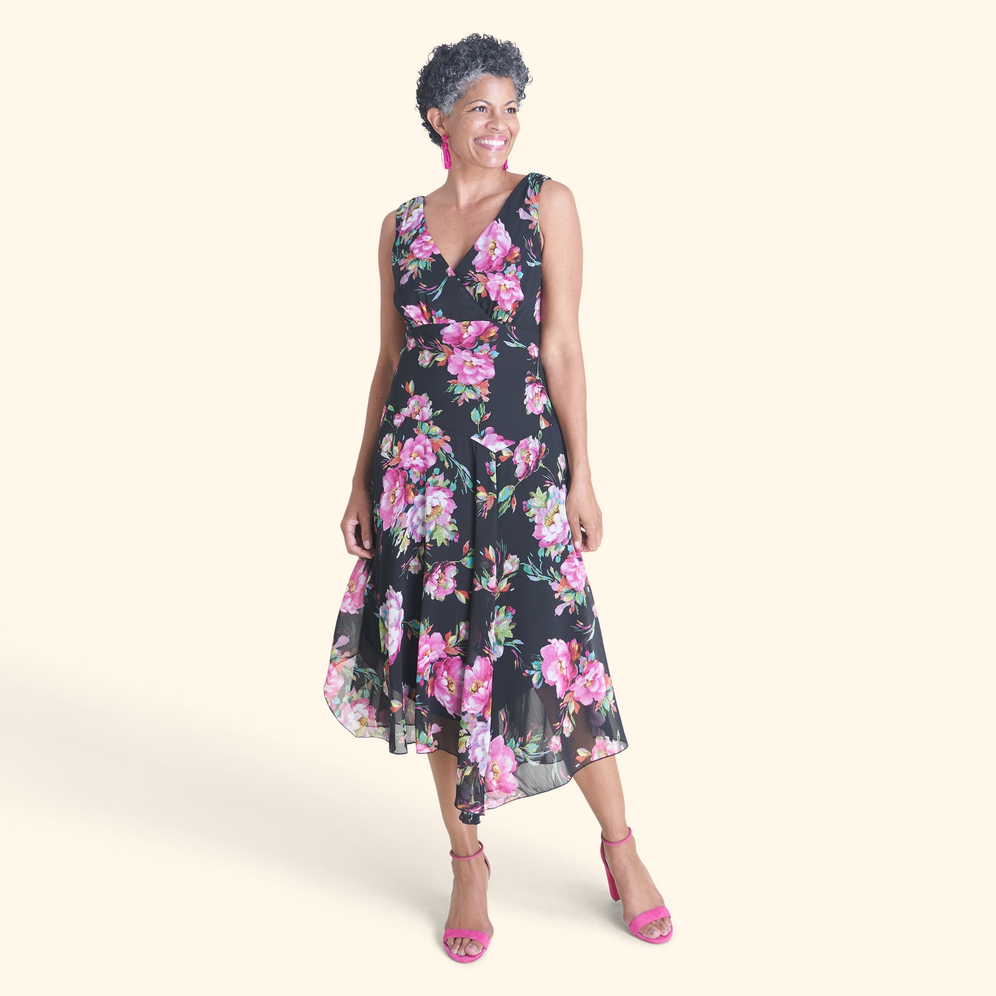Woman posing wearing Black Audrey Floral Surplice Asymmetrical Midi Dress from Connected Apparel