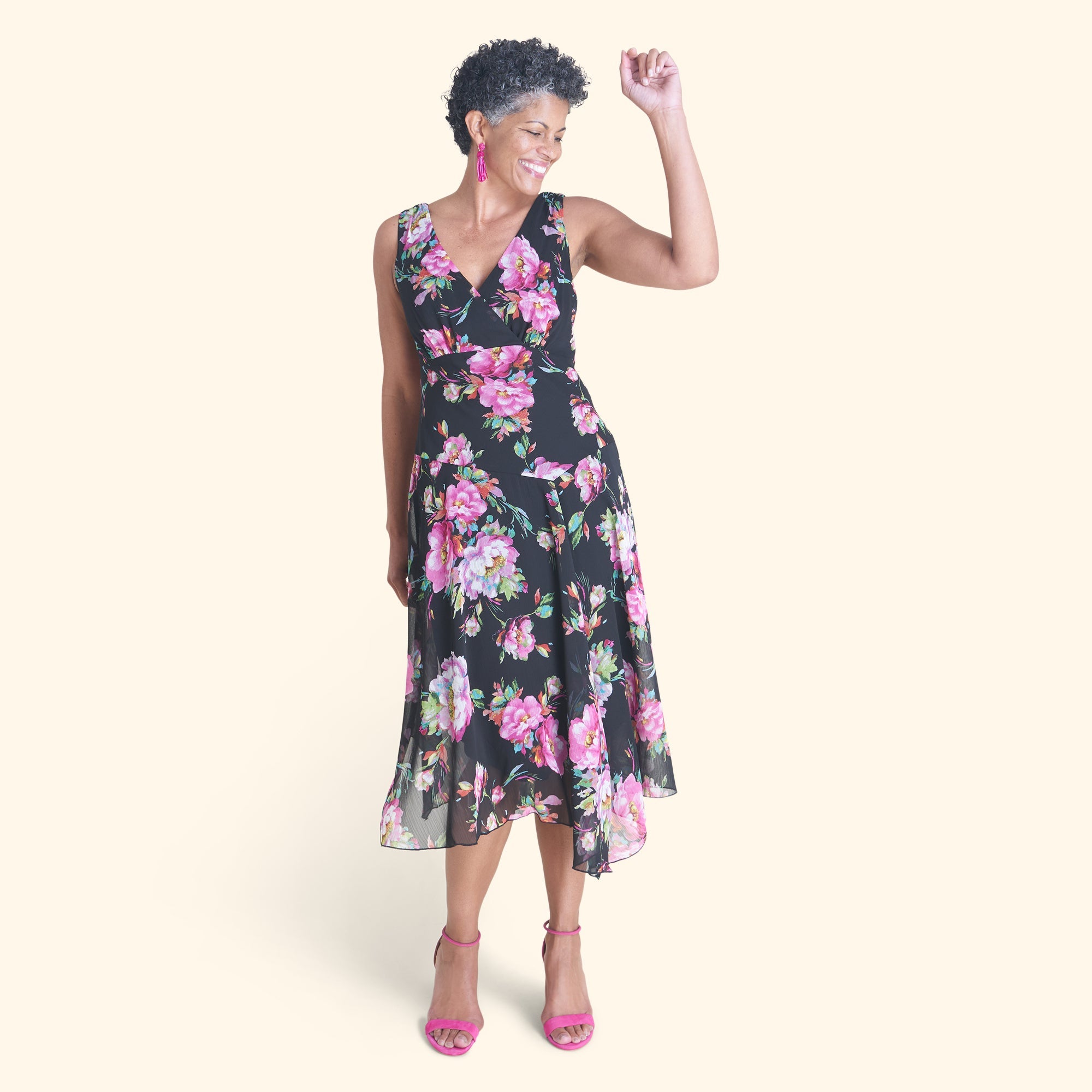 Woman posing wearing Black Audrey Floral Surplice Asymmetrical Midi Dress from Connected Apparel