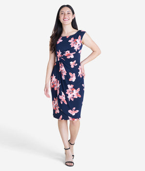 Woman posing wearing Melon Lisa Melon Floral Faux Wrap Dress from Connected Apparel