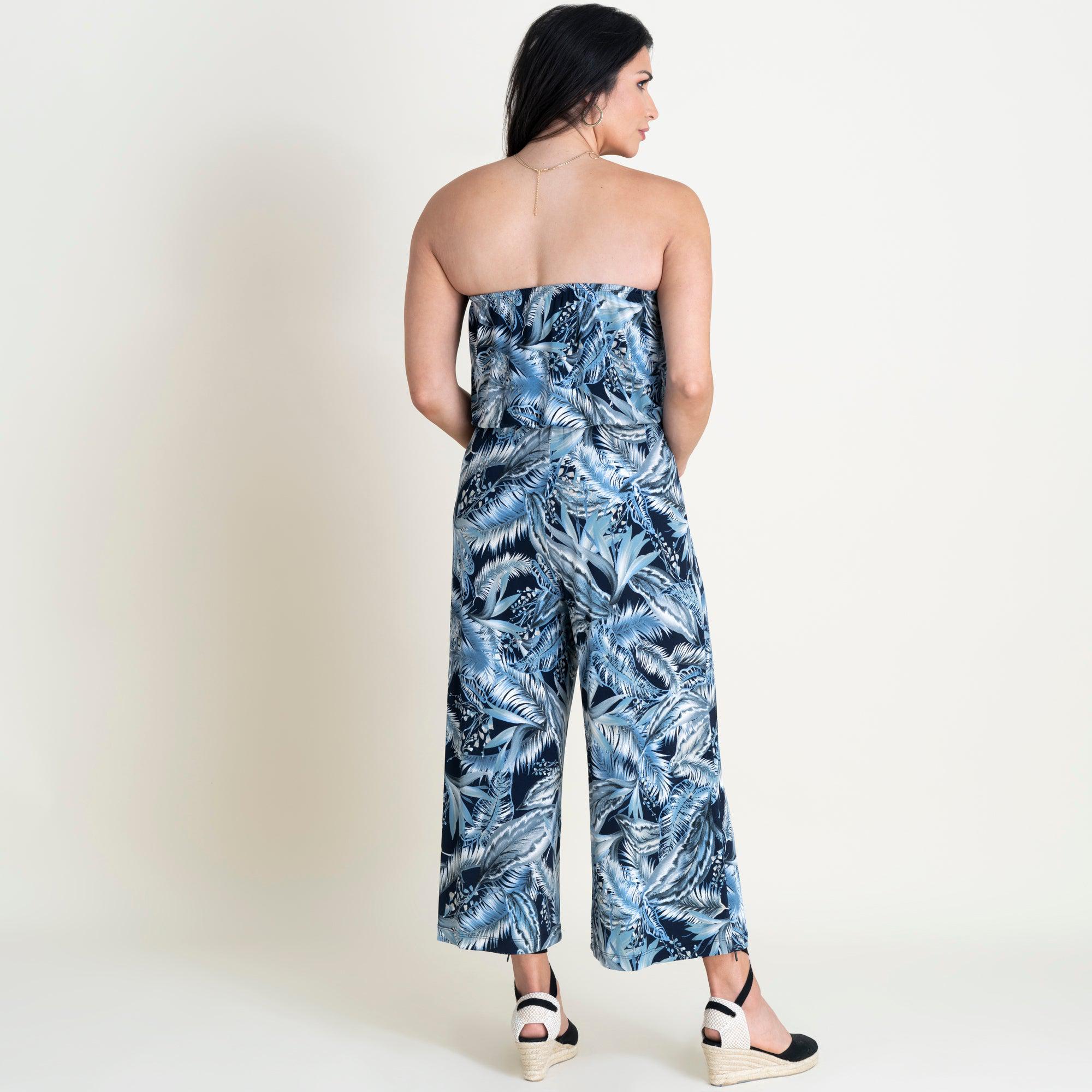 Woman posing wearing Navy Melissa Leaf Print Strapless Jumpsuit from Connected Apparel