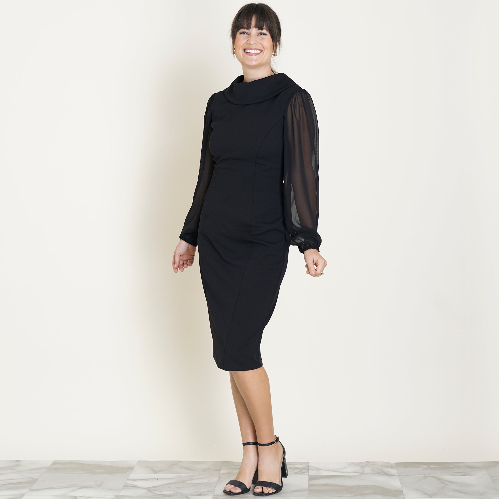 Woman posing wearing Black Jana 2.0 Long Sleeve Little Black Dress from Connected Apparel