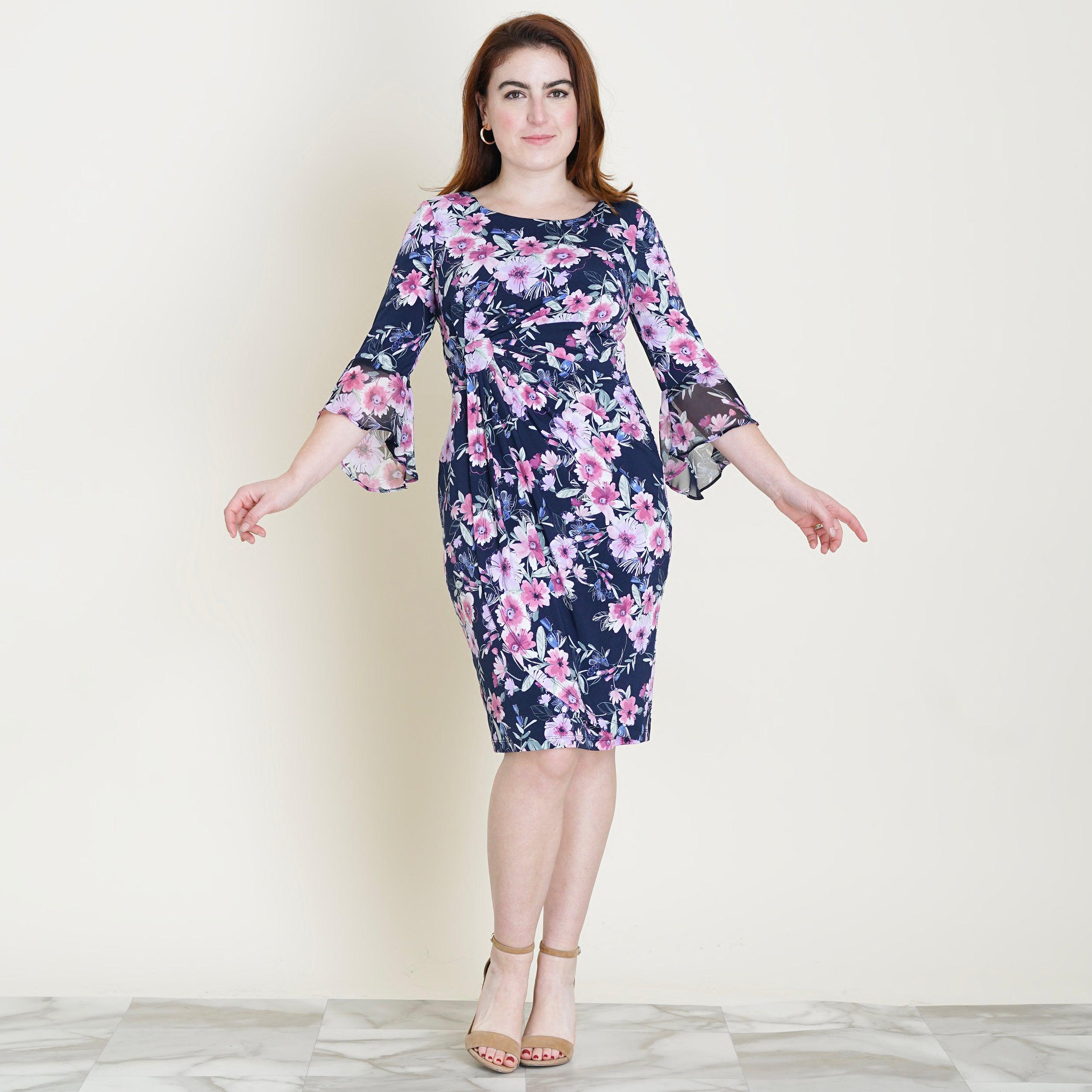 Woman posing wearing Navy/Mauve Lisa 2.0 Navy and Mauve Floral Faux Wrap Dress from Connected Apparel