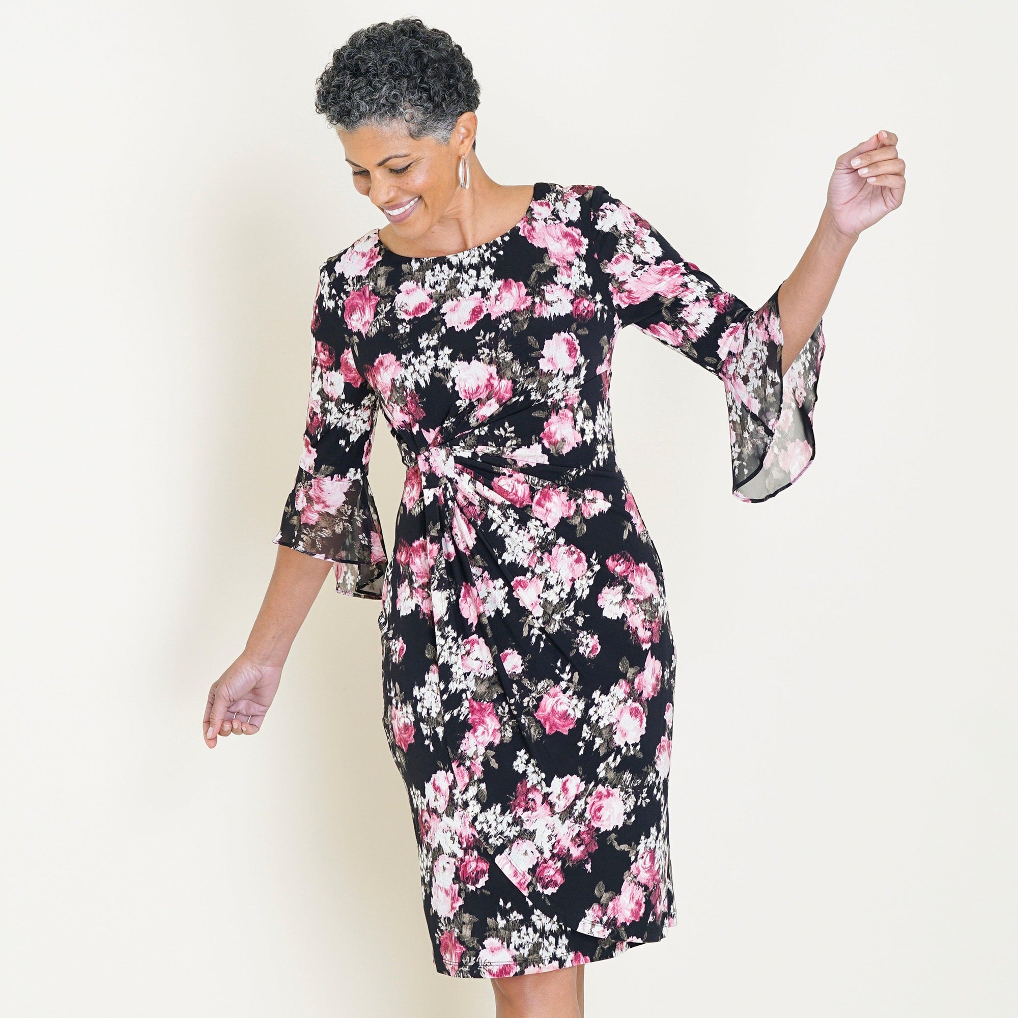 Woman posing wearing Black/Rose Lisa 2.0 Rose Floral Faux Wrap Dress from Connected Apparel