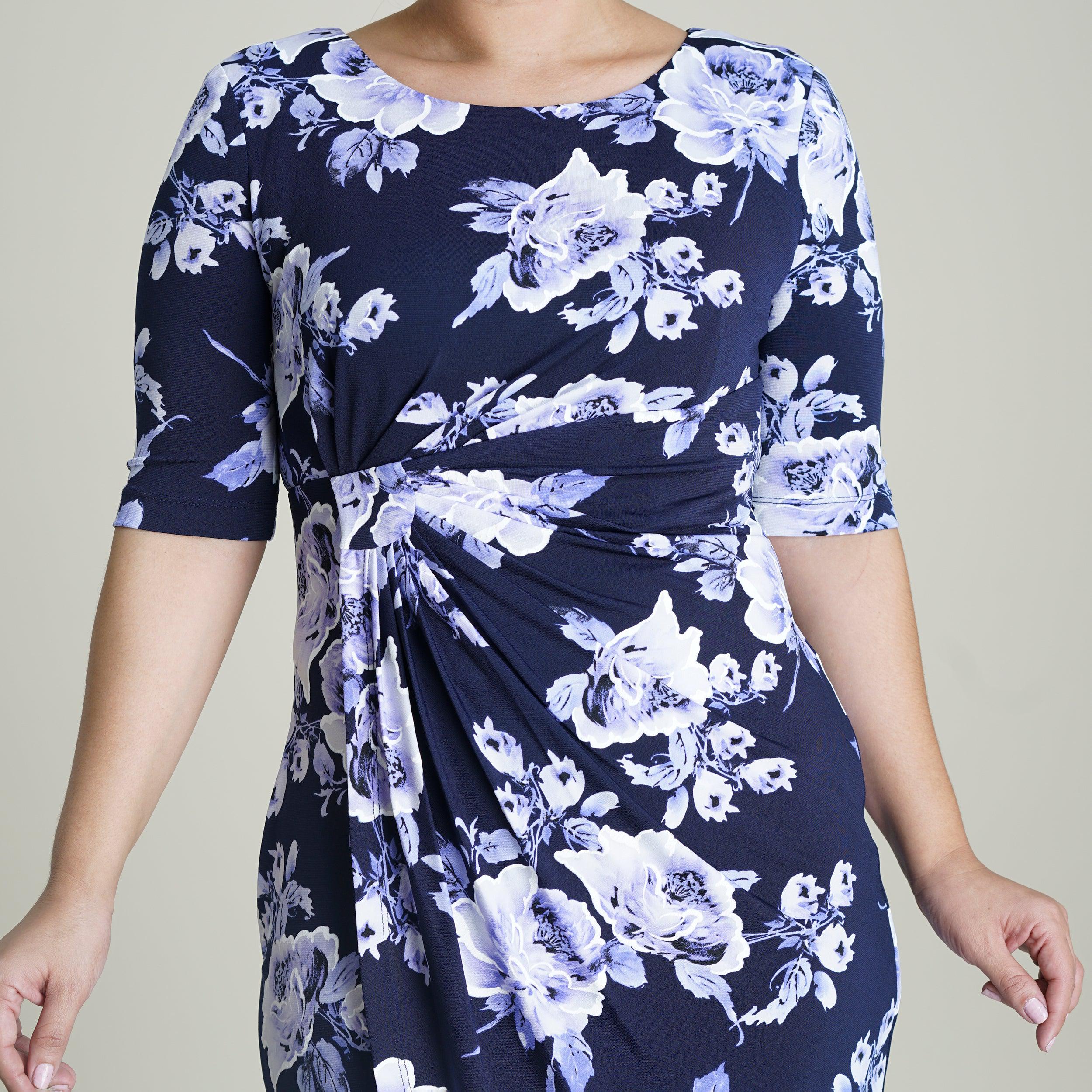 Woman posing wearing Periwinkle Lisa Periwinkle Floral Faux Wrap Dress from Connected Apparel