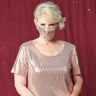 Woman posing wearing Rose Gold CAxLZ Rose Gold Sequin Face Mask from Connected Apparel